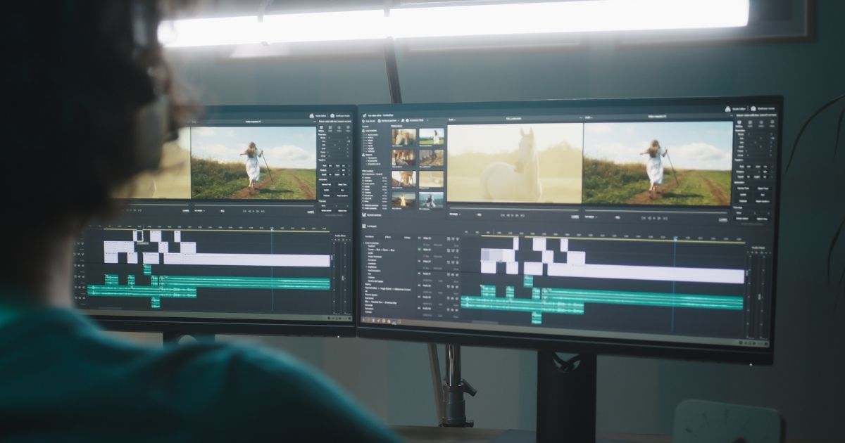شخص يعمل على برنامج تحرير فيديو باستخدام شاشتين.